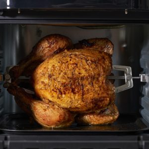 Crust air fryer with chicken in rotisserie